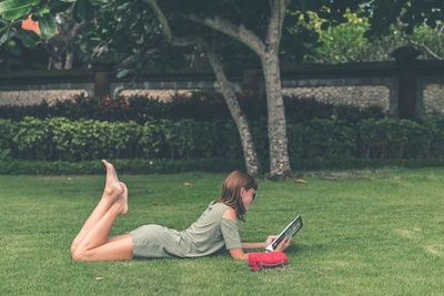 Girl on the lawn in the park reads a book