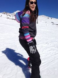 Full length of smiling woman on snow covered field