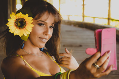 Portrait of young woman holding mobile phone