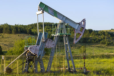 Metallic structure on field against sky