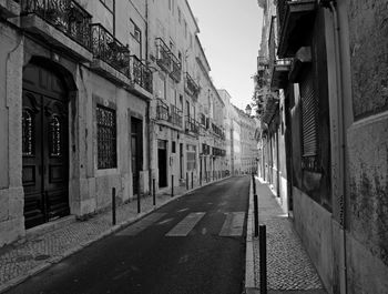 Empty road along buildings