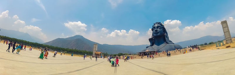 Panoramic view of people on land against sky