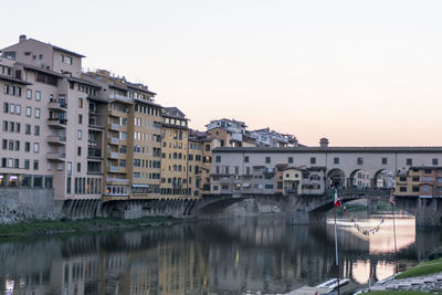 Ponte vecchio reflected in the arno river at sunset 