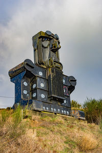 Low angle view of old ruin on field against sky