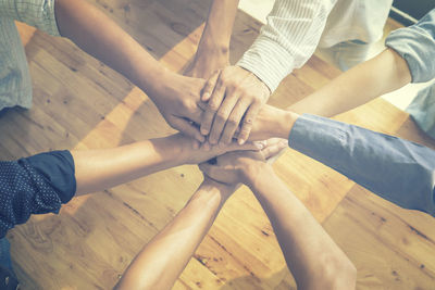 High angle view of businesspeople stacking hands over table