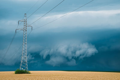 Scenic view of electricity pylon on field against sky