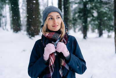 Portrait of a woman on a winter day standing outside in winter clothes.