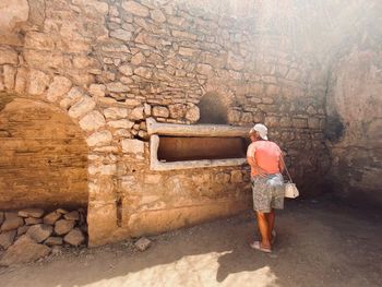 Rear view of man walking on stone wall