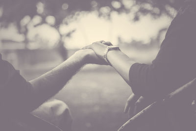 Low section of couple kissing against sky