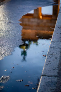 Reflection of road in puddle on street
