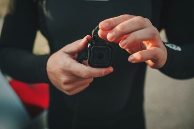 Midsection of man holding camera