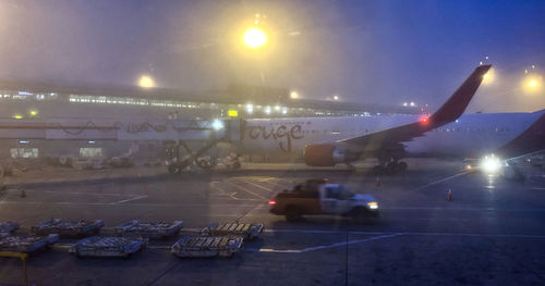 Airplane on runway against sky at night