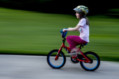 Full length of boy riding push scooter on field