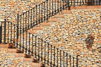 Staircase by stone wall of building