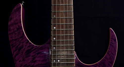 Close-up of guitar against black background