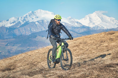 Rear view of man riding bicycle on mountain