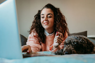 Portrait of woman with dog sitting at home