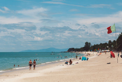 People at beach against sky