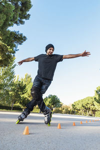 Low angle view of man skating on road against clear sky