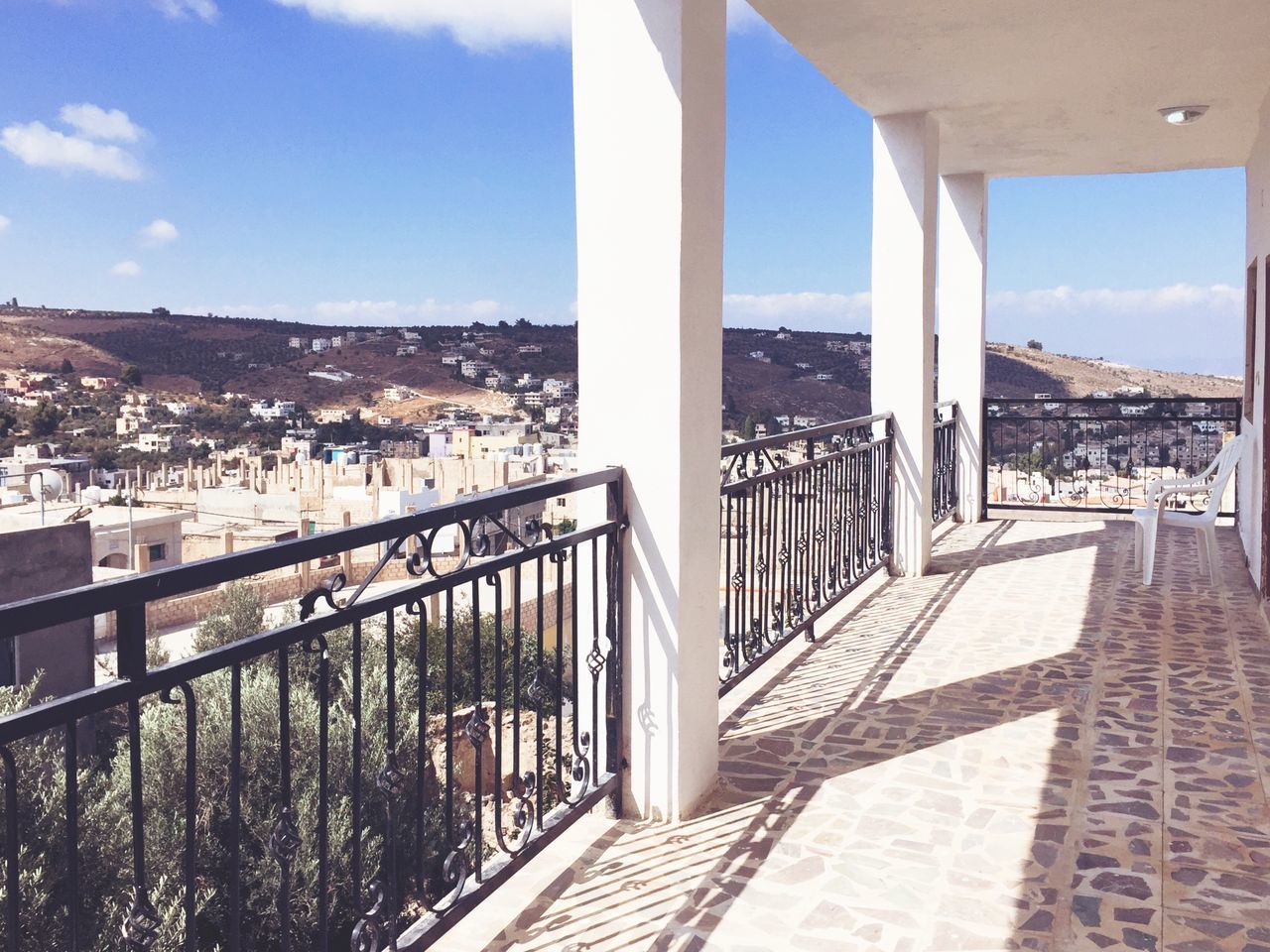 railing, architecture, built structure, shadow, sunlight, sky, building exterior, residential building, city, sunny, balcony, residential district, day, cloud, the way forward, railings, outdoors, cloud - sky, city life