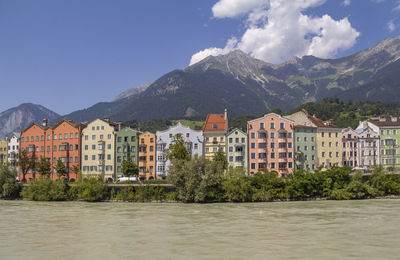 Scenic view of river and buildings in city against sky