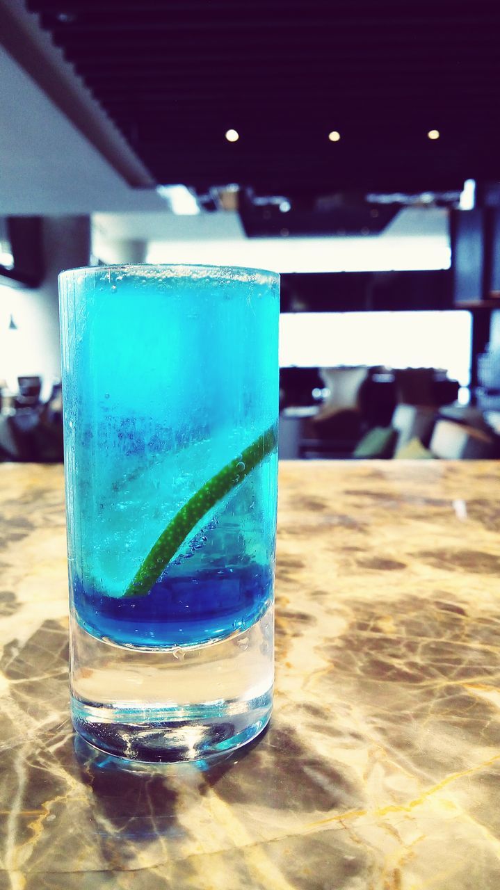 drink, table, food and drink, drinking glass, refreshment, indoors, still life, focus on foreground, freshness, close-up, glass - material, drinking straw, transparent, blue, glass, alcohol, selective focus, no people, day, bottle