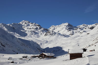 Scenic view of snowcapped mountains against clear blue sky