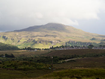 Scenic view of field and mountains against sky