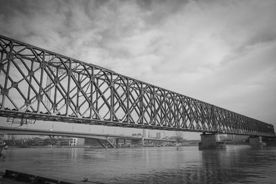 Low angle view of bridge over river against sky