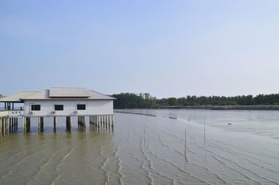 Building by lake against clear sky