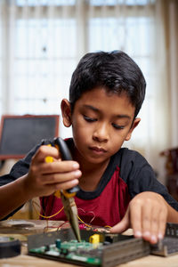 Portrait of boy holding table