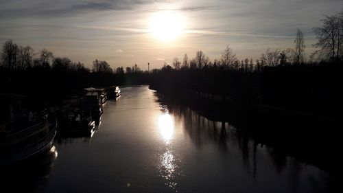 Scenic view of canal against sky during sunset