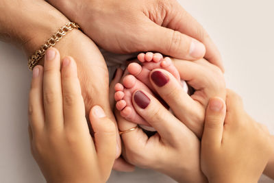 Cropped hands of woman massaging against white background