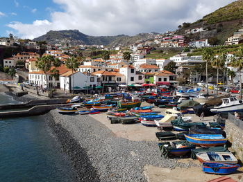 Boats moored at harbor by sea against sky