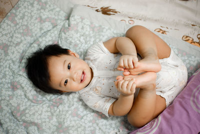 Portrait of cute baby lying on bed