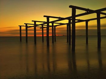 Pier on sea at sunset