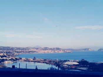 High angle view of city by sea against sky