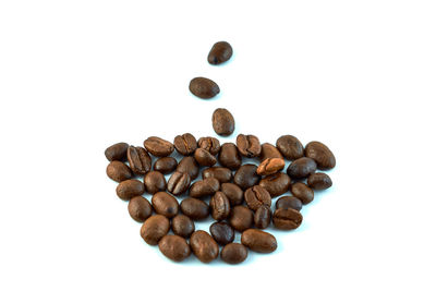 High angle view of coffee beans against white background