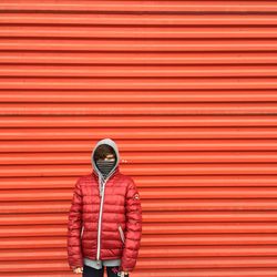 Full length of man standing on red umbrella