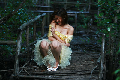 Laughing young woman posing in dress outdoors