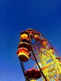 Low angle view of ferris wheel against blue sky