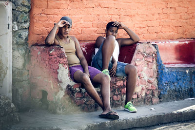 Full length of woman sitting on wall