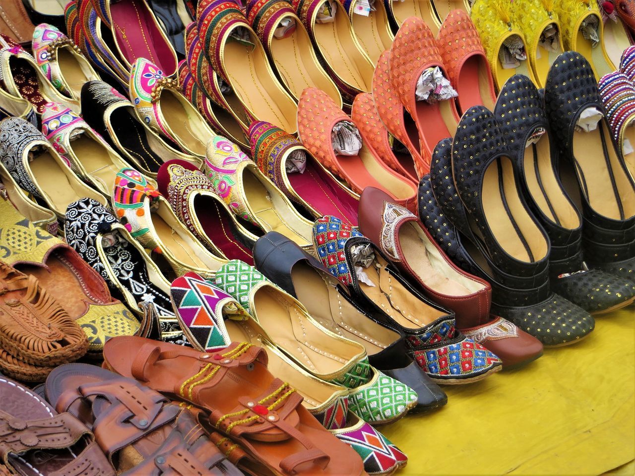 HIGH ANGLE VIEW OF MULTI COLORED SHOES AT MARKET STALL