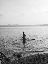 Man in sea against sky