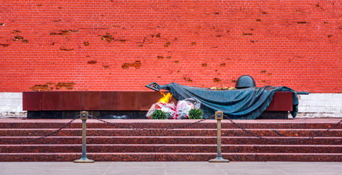 Man sleeping on brick wall