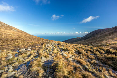 Scenic view of landscape and mountains against blue sky