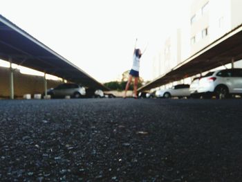 Low section of person on road in city against sky