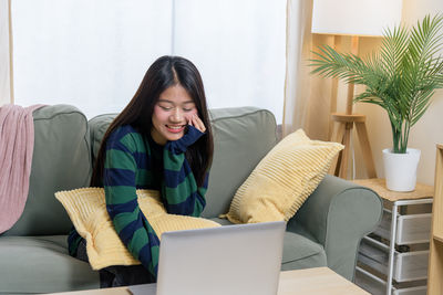 Young woman using laptop at home