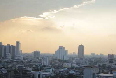 Aerial view of buildings in city against sky