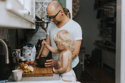 Father with toddler preparing food